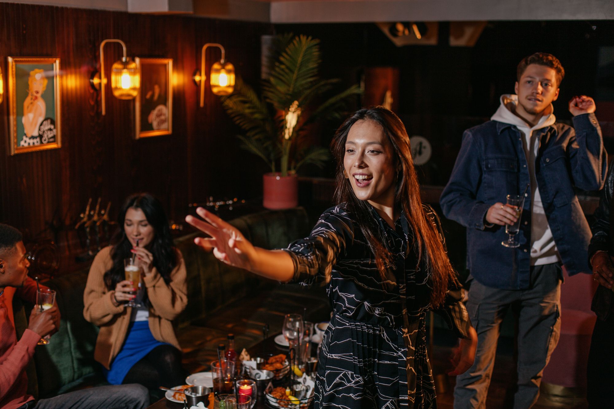 A lively group of friends enjoying a fun party atmosphere whilst playing darts, filled with laughter and celebration.