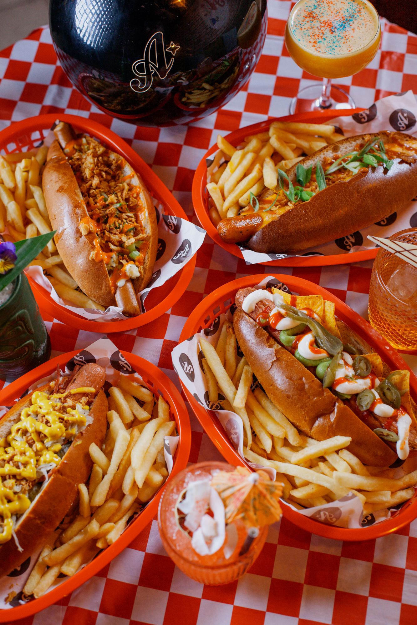 A neatly set table covered with a decorative tablecloth, showcasing an elegant dining arrangement of hotdogs and fries.